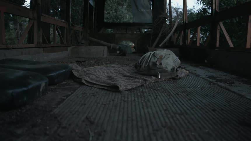 Backpack resting over a blanket on the bed of a truck in the countryside at morning