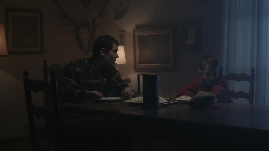 A man abruptly leaves the dining room table after seeing headlights outside