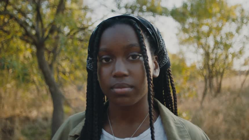 A teenager poses in the woods