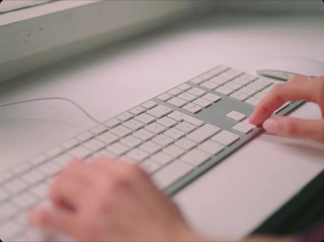 An employee is working in an office and is on her computer