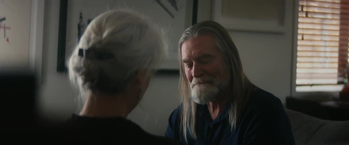 An older couple are inside of there home and are having a conversation