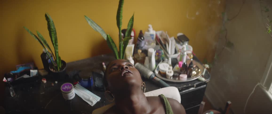 A woman leans back in her chair smoking