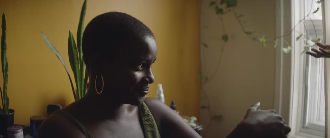 A young woman is sitting inside of her room and talking to a friend