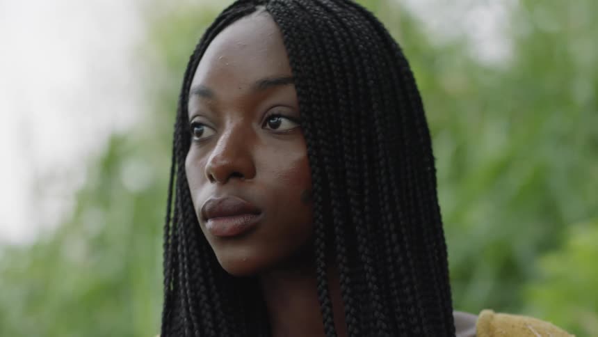 A woman looks around while standing outside