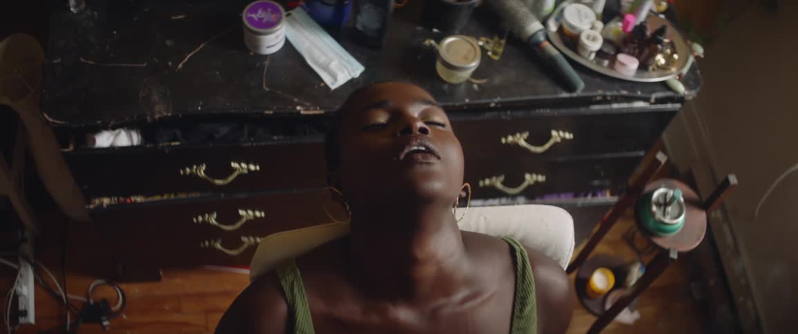 Black woman relaxing in bedroom smoking a joint