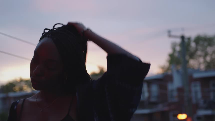A young woman is standing outside in the middle of the day