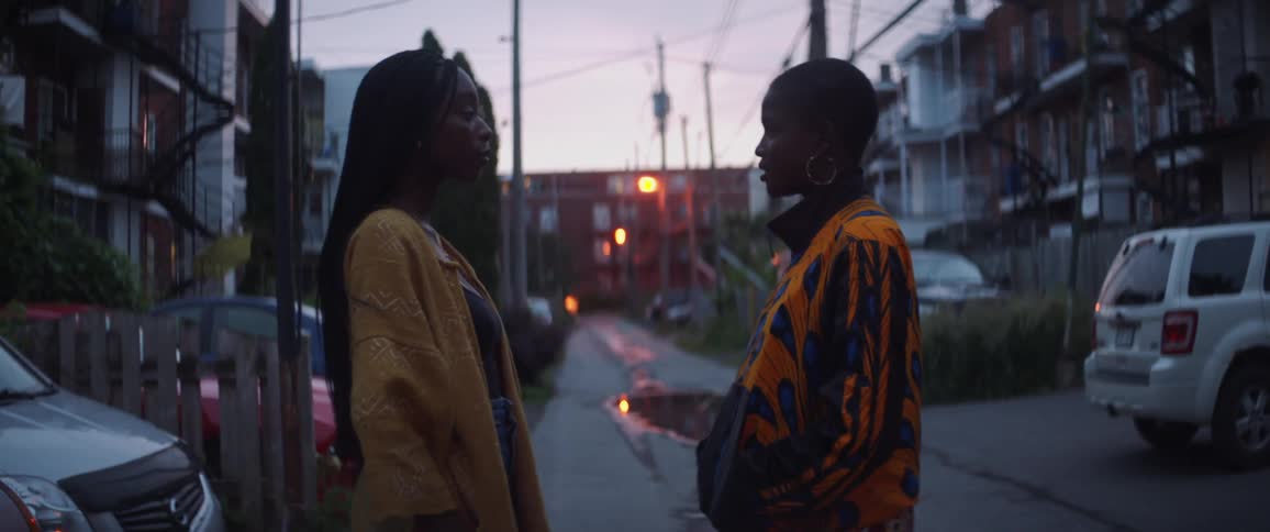 Two black women stand in the street speaking