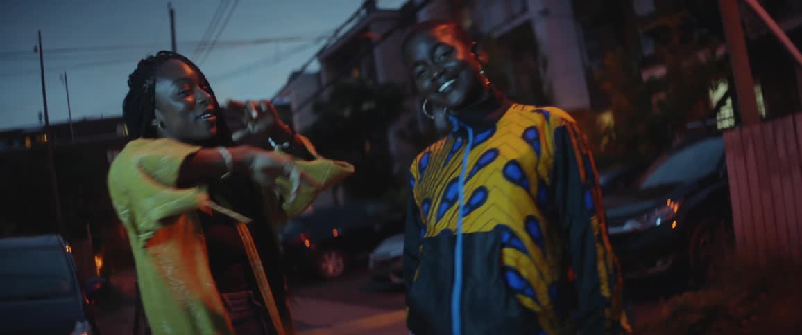 Two women dancing around outdoors at night