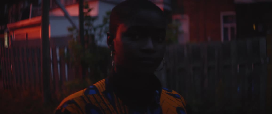 Young woman standing on the neighborhood streets at sunset