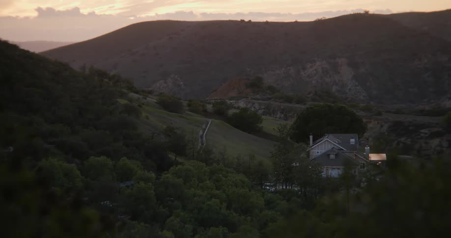 House nested on a small valley in the mountains at evening