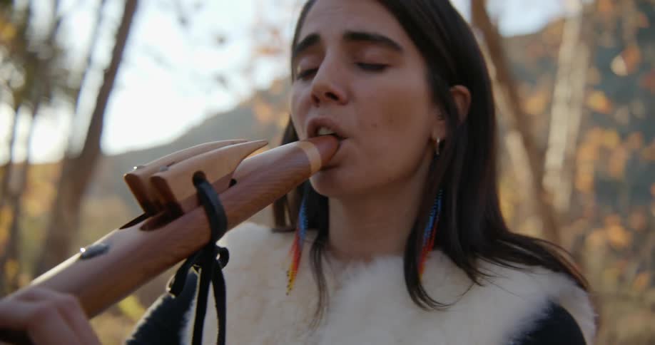 A woman playing a flute outdoors