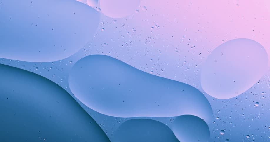 Blobs and bubbles of translucent liquid gently flowing over a blue and magenta background