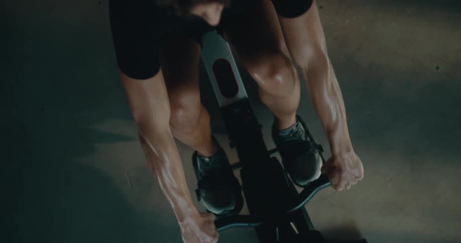 Top down view of a strong muscular man sweating while working out on a rowing machine