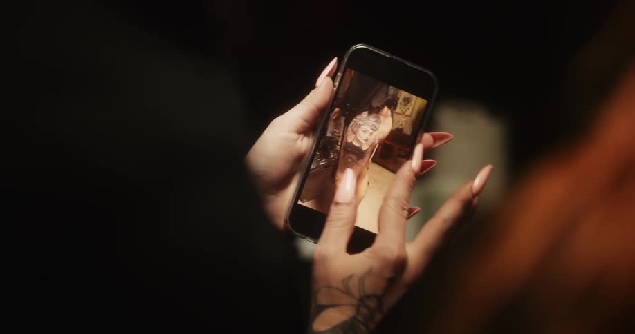 A woman is looking at a picture on her cell phone