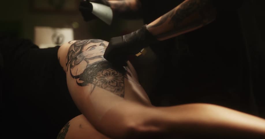 A tattoo artist puts a bandage on a new tattoo