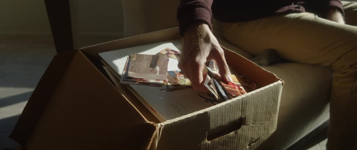 A man removes photos from the box