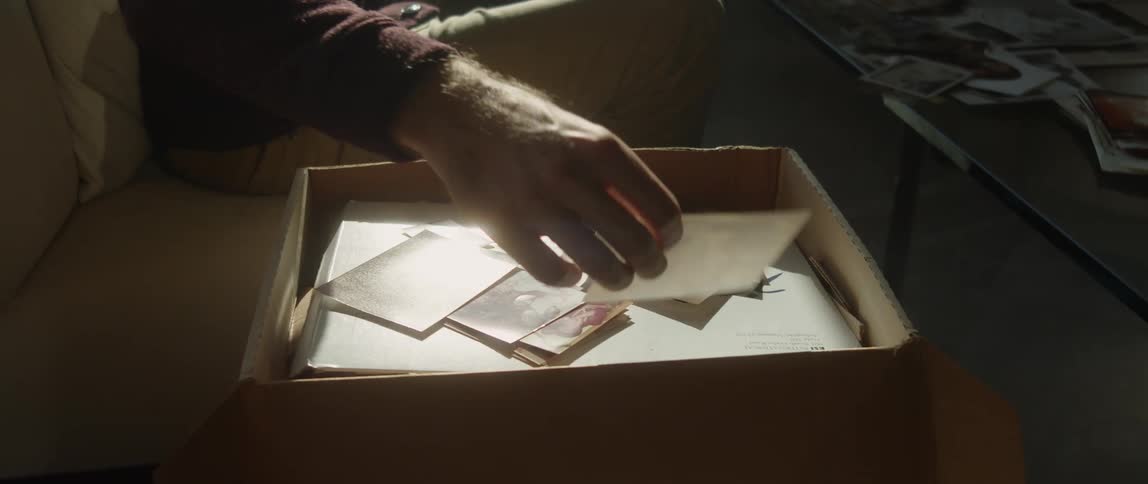 A man lifts a photo from the box