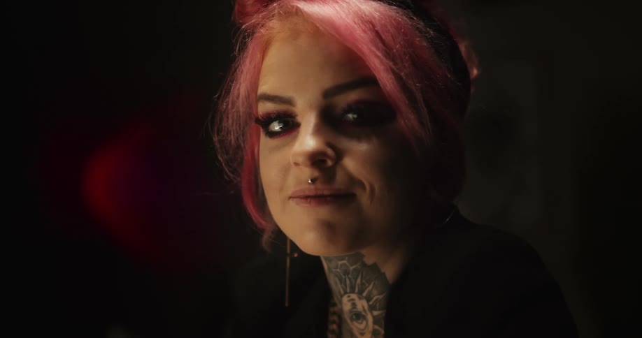 A woman with a tattoo on her neck is smiling