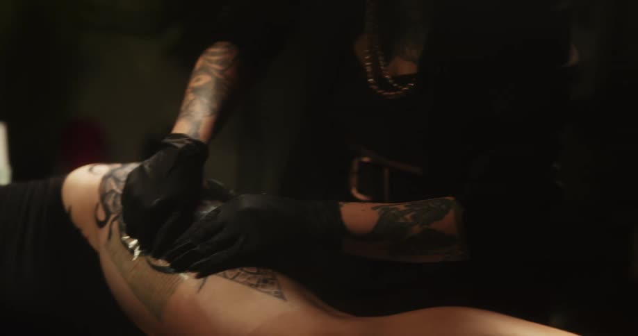 The tattoo artist is covering the tattoo