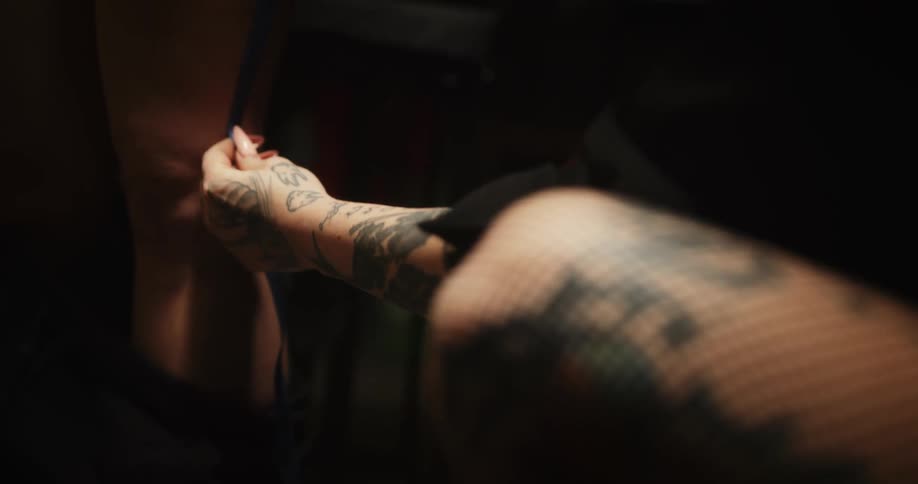 Tattoo artist using a measuring tape on the leg of a customer