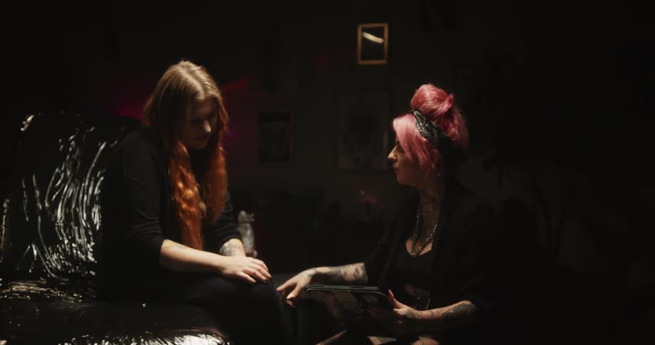 A tattoo artist is talking to a client
