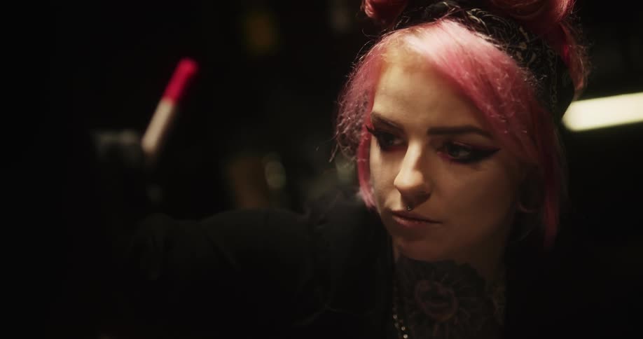 A woman draws something on someone elses body part that is barely showing