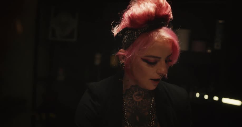 A tattoo artist scrolls on a tablet and shows a client designs