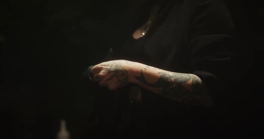 Tattoo artist puts on black latex gloves before working on the skin of a client