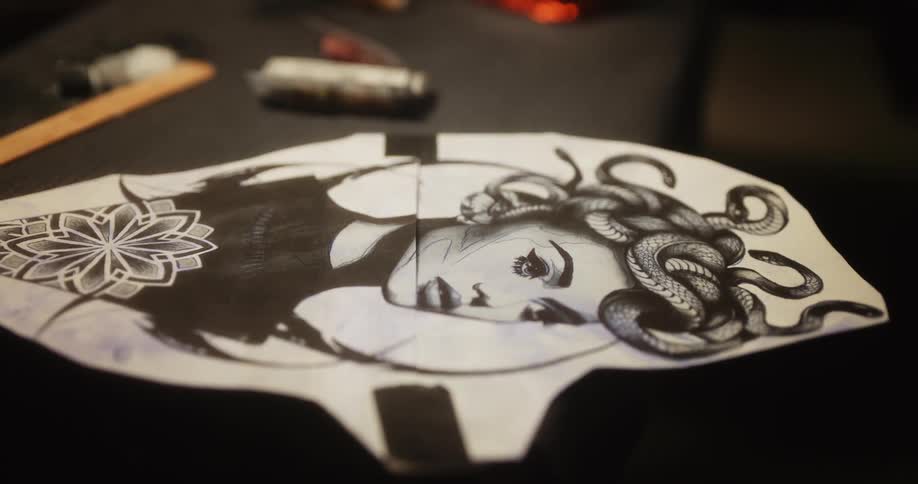 Close up of a black and white drawing of a modern medusa on paper