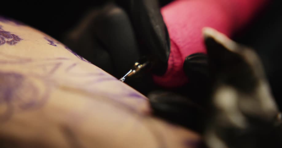 Close up of a tattoo artist cleaning the skin of a customer after a tattooing session