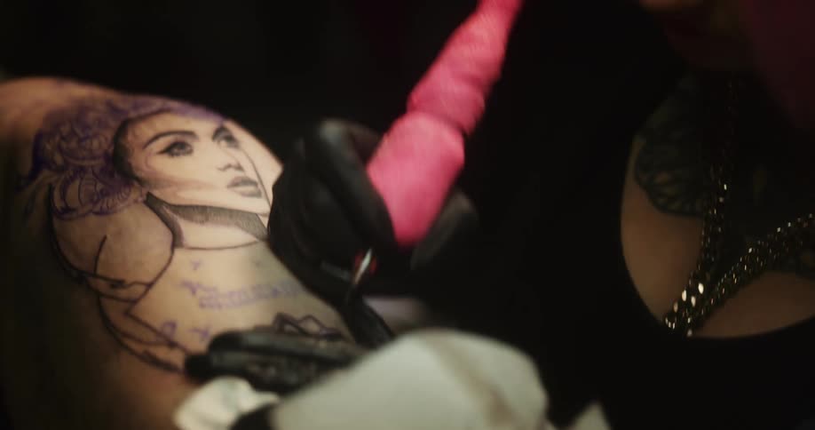 A tattoo artist working on a clients hip and thigh