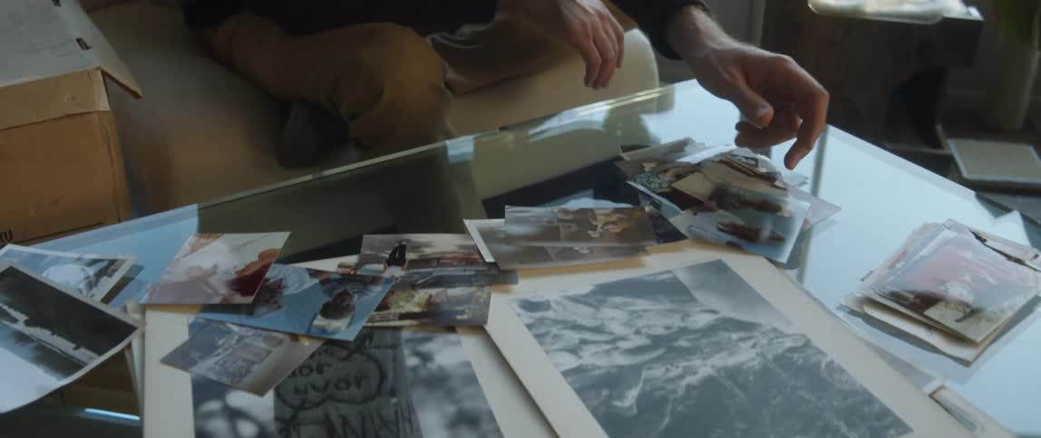 A man looks at photos on a coffee table at home