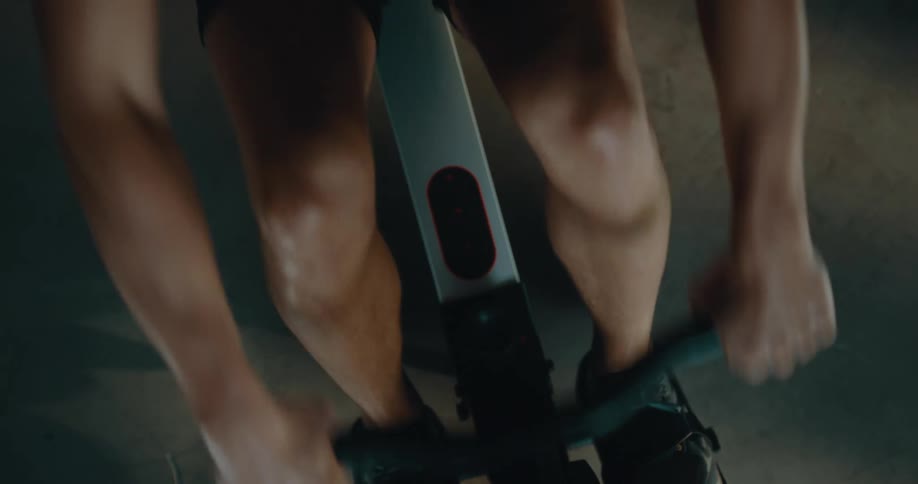 Top down view of a strong muscular man sweating while working out on a rowing machine