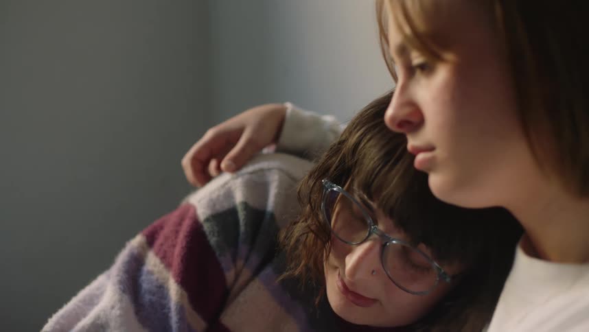 Young couple comfortably sitting on the bed cuddle comfortingly