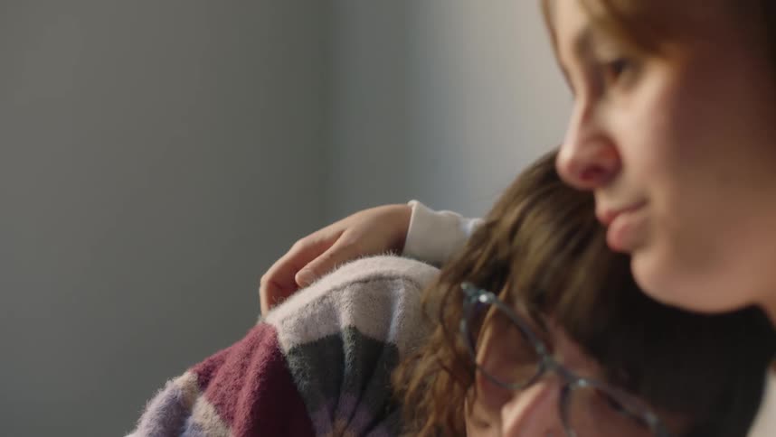 Young couple comfortably sitting on the bed cuddle comfortingly