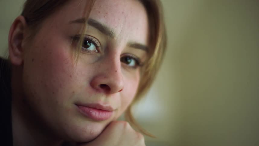 Young blonde freckled woman looking at the camera
