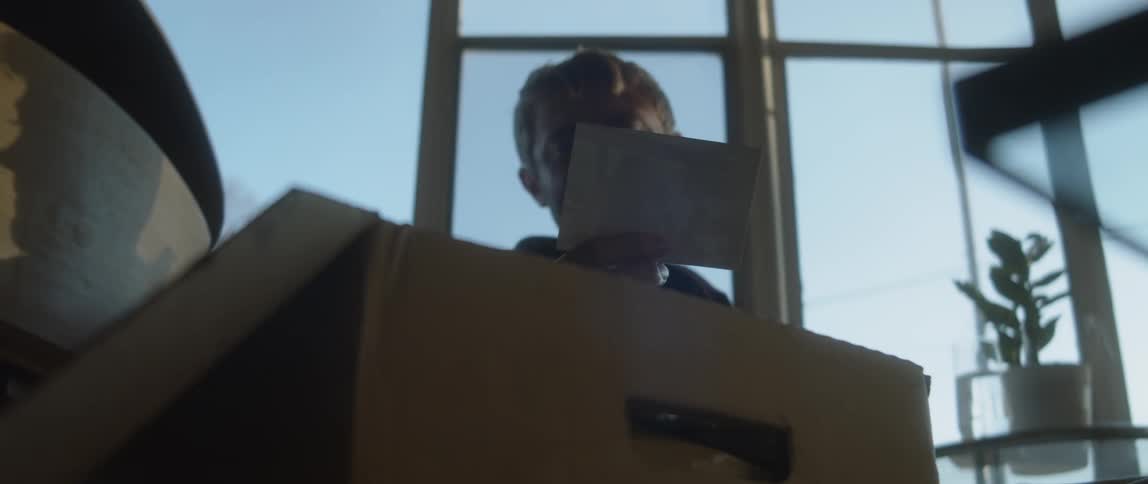 A man lifts a photo from the box