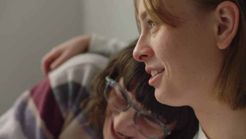 Young happy couple sitting together cuddle comfortingly in the bedroom