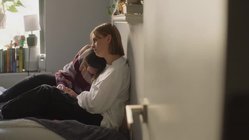 Young couple comfortably sitting on the bed cuddle comfortingly