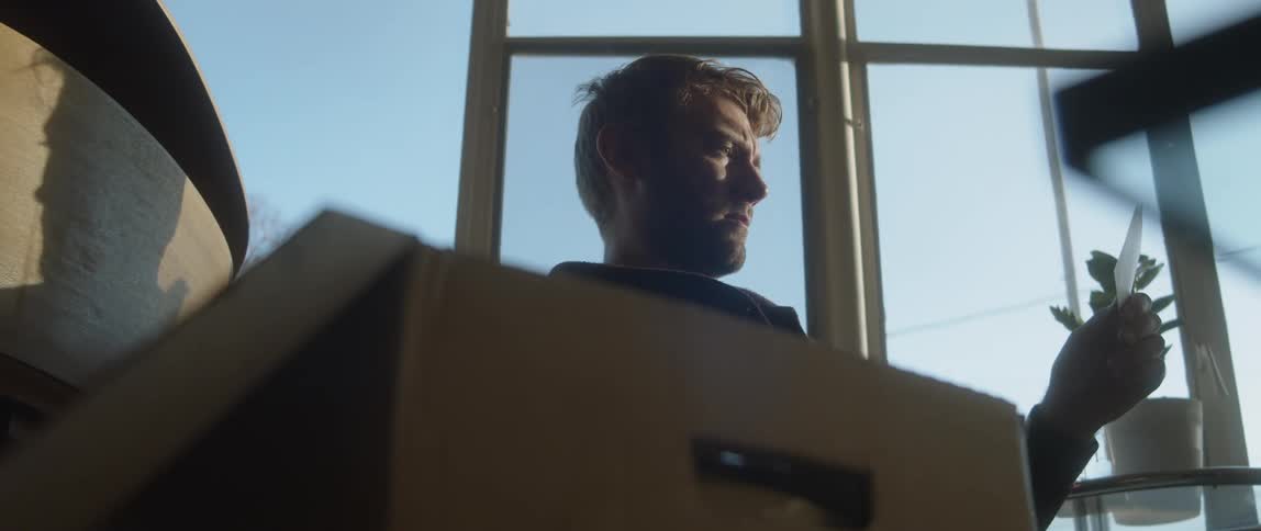 A man grabs a photo from a box at home