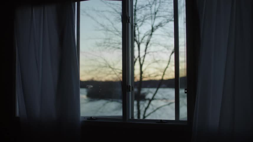 Calm winter landscape seen through a window at evening