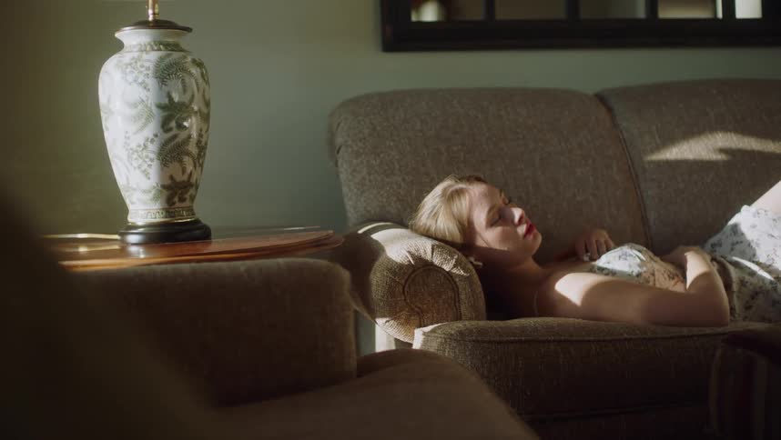 Sunlight shines on a woman sleeping on her living room couch