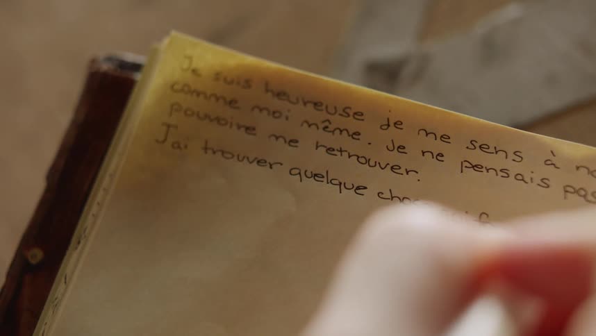 A person is using a pen to write in a book