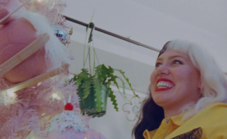 Close up of the faces of a young happy couple decorating a christmas tree at home
