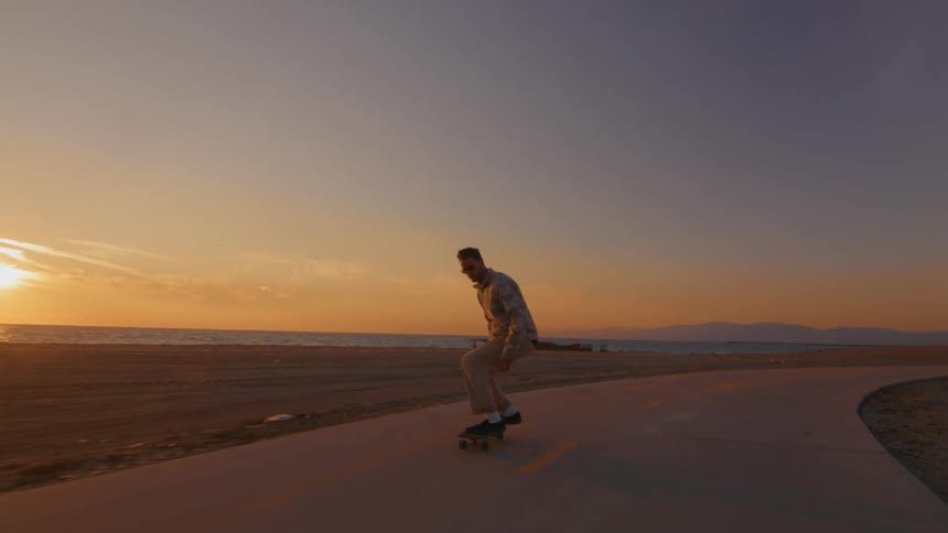 A man skateboarding down a street jumps performs a jump on his skateboard