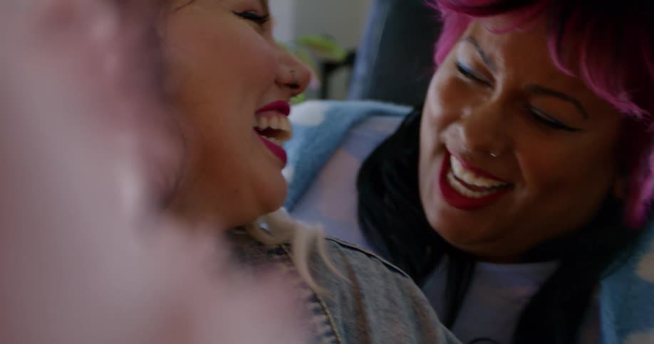 Close up of the faces of a young happy couple decorating a christmas tree at home