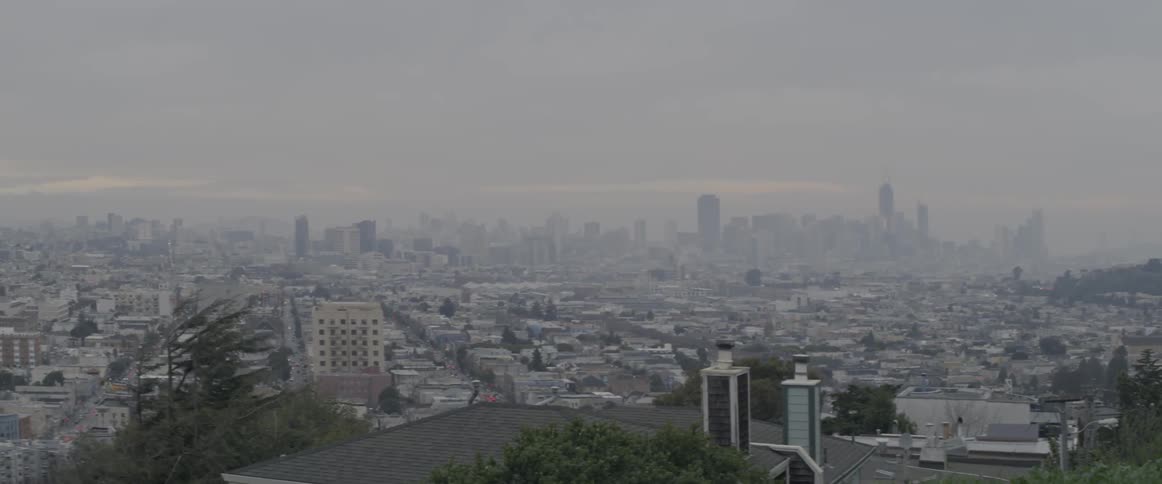 A city has heavy fog covering it in the distance