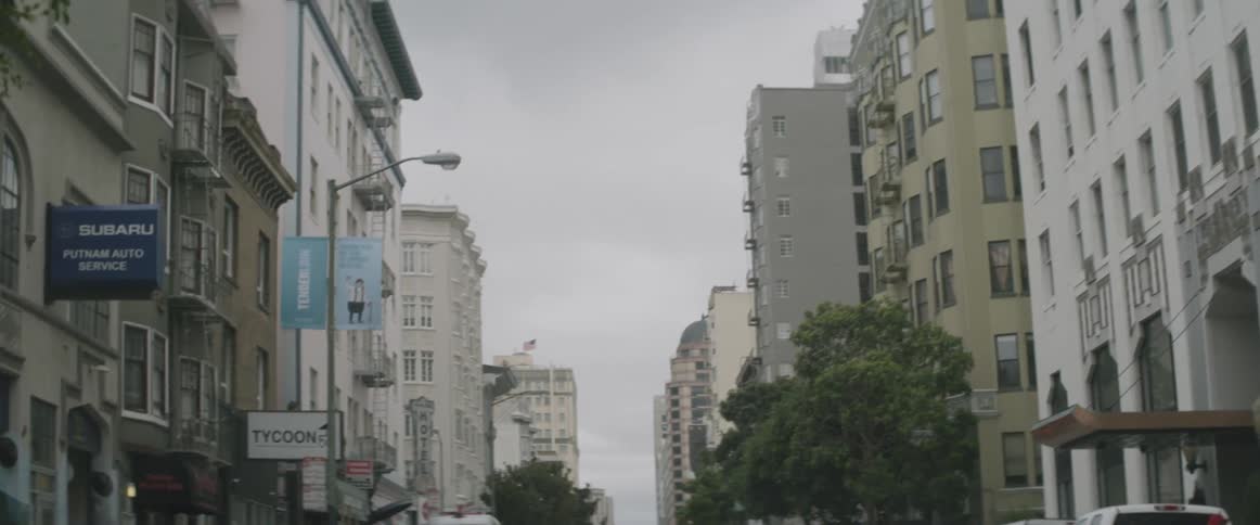 Tall buildings line this city on a cloudy day