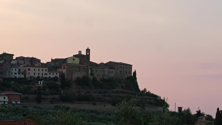 Buildings sit on a hill overlooking a field