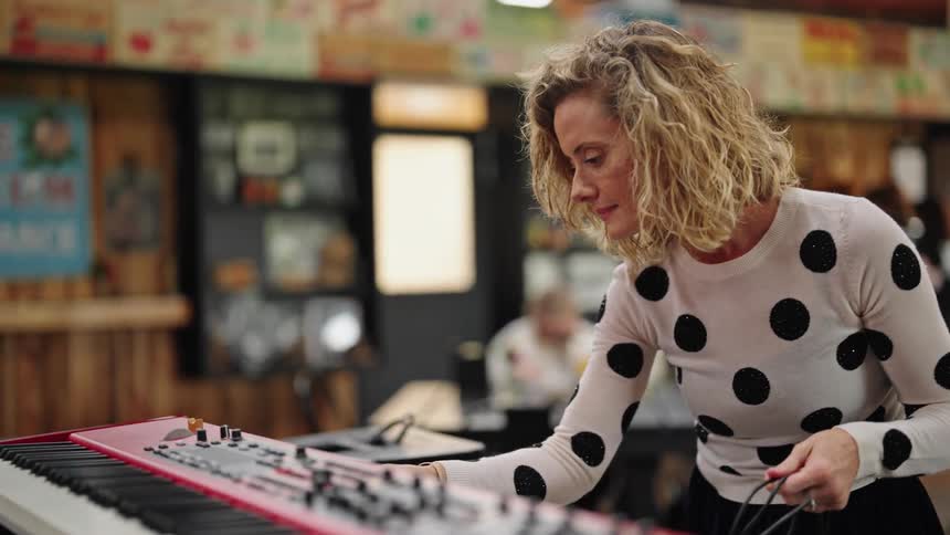 A woman plugs in a keyboard